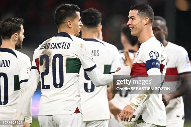 Portugal's forward Cristiano Ronaldo celebrates with Portugal's defender Joao Cancelo after opening the scoring during the UEFA Euro 2024 Group J...