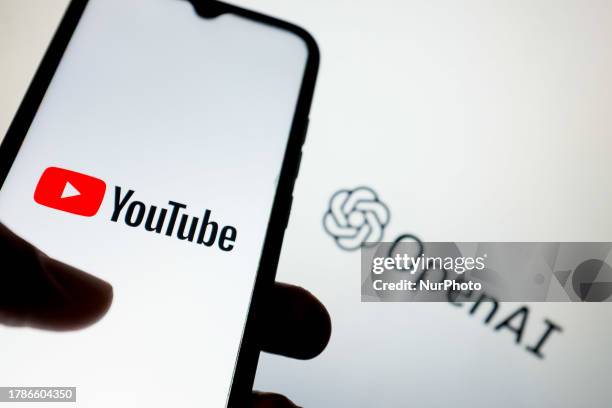 In this photo illustration a YouTube logo seen displayed on a smartphone screen and an OpenAI logo in the background in Athens, Greece on November...