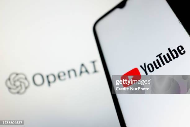 In this photo illustration a YouTube logo seen displayed on a smartphone screen and an OpenAI logo in the background in Athens, Greece on November...