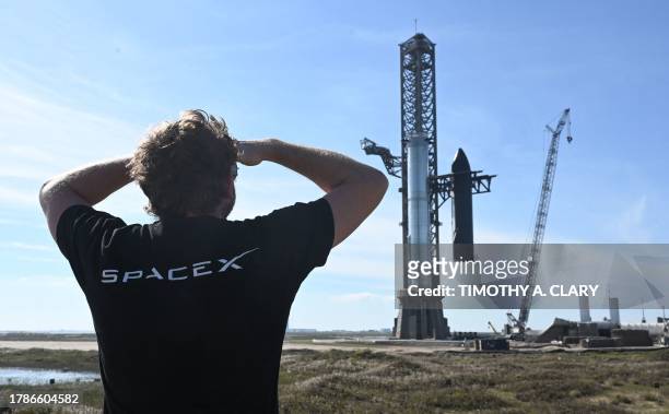Person looks on as SpaceX's huge Super Heavy-Starship is unstacked from the booster as it sits on the launchpad at Starbase in Boca Chica, Texas, on...