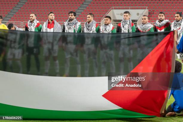 Players of Palestine open a Palestinian flag ahead of the 2026 FIFA World Cup Asian qualifiers group I soccer match between Lebanon and Palestine at...