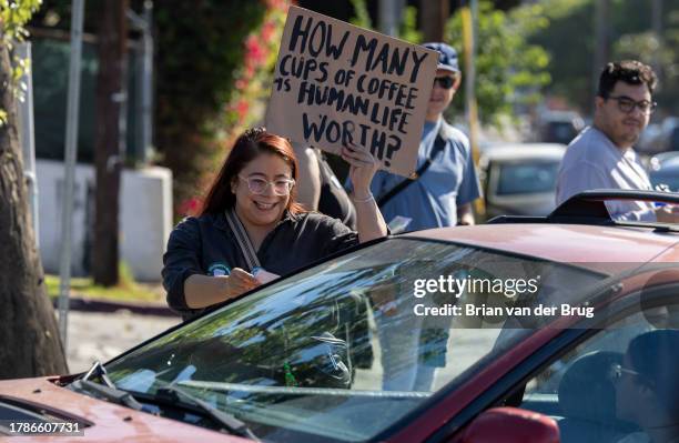 Los Angeles, CA Volunteer organizer Elizabeth Fernandez passes out information as a push to unionize Starbucks workers continues in front of a...