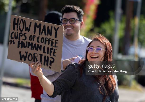 Los Angeles, CA Volunteer organizer Elizabeth Fernandez holds a sign as a push to unionize Starbucks workers continues in front of a Starbucks store...