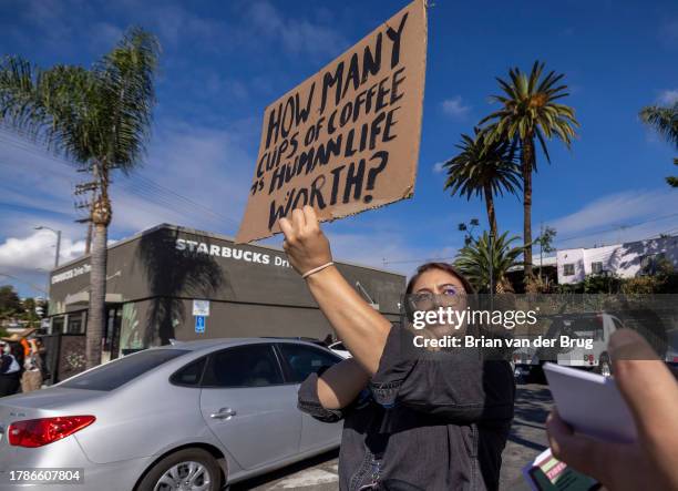 Los Angeles, CA Volunteer organizer Elizabeth Fernandez holds a sign as a push to unionize Starbucks workers continues in front of a Starbucks store...