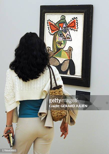 Visitor looks at a Picasso's painting "Woman with a hat in an armchair" , on June 9, 2011 at the Granet museum in Aix-en-Provence, southern France as...