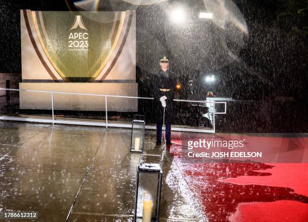 Member of the military stands along a flooded red carpet ahead of the leaders and spouses dinner during the Asia-Pacific Economic Cooperation...