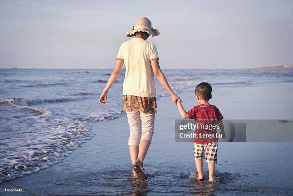 Mother and boy walking on the beach