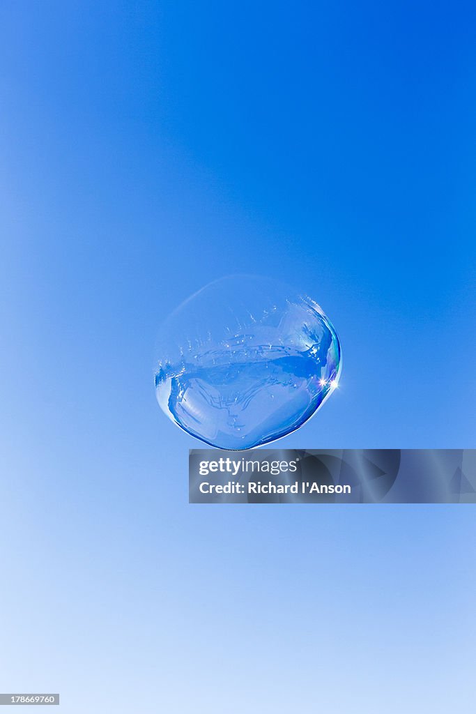 Bubble floating in blue sky
