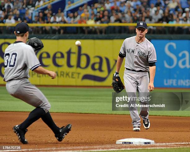 Infielder Lyle Overbay of the New York Yankees tosses an infield hit to pitcher David Robertson at first base against the Tampa Bay Rays August 25,...