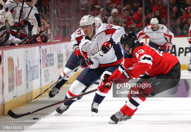 Nicolas Aube-Kubel of the Washington Capitals and Luke Hughes of the New Jersey Devils go after the puck during the first period at Prudential Center...