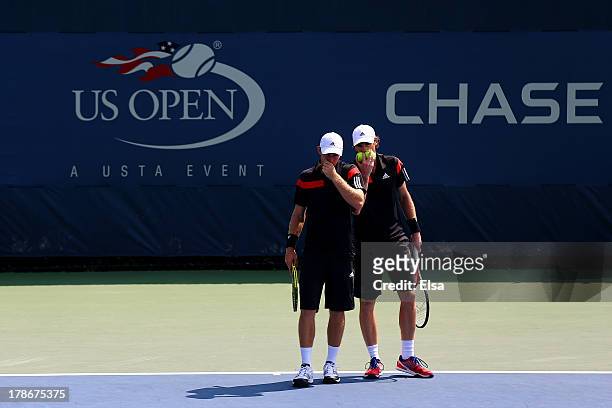 Jamie Murrary of Great Britain and John Peers of Australia talk tactics during their men's doubles second round match against Feliciano Lopez of...