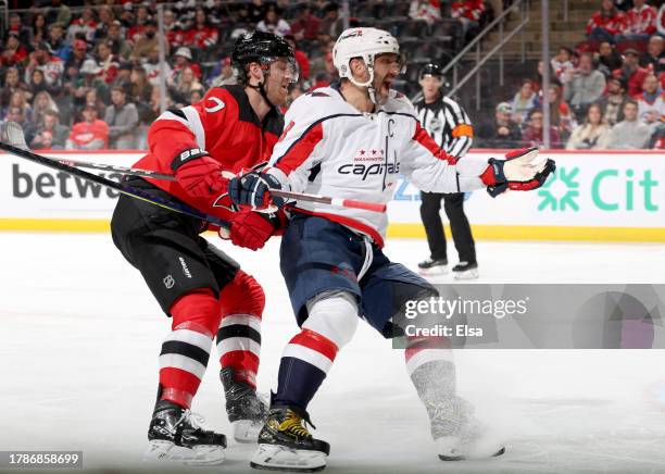 Alex Ovechkin of the Washington Capitals reacts as Dougie Hamilton of the New Jersey Devils defends during the third period at Prudential Center on...