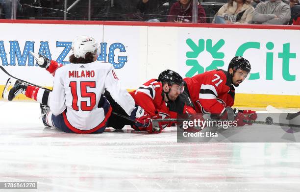 Sonny Milano of the Washington Capitals, Chris Tierney and Jonas Siegenthaler of the New Jersey Devils collide as they go after the puck during the...