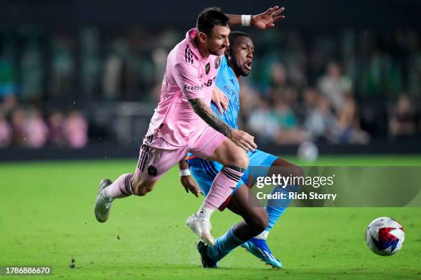 Lionel Messi of Inter Miami CF collides with Andres Perea of New York City FC during the second half in the Noche d'Or friendly match at DRV PNK...