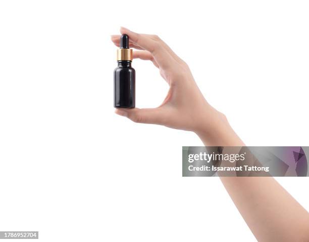woman hand holding a bottle serum isolated on white background. - dropper bottle stock pictures, royalty-free photos & images