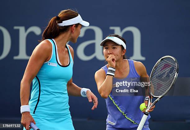 Shuko Aoyama of Japan talks tactics with her partner Chanelle Scheepers of South Africa during their women's doubles first round match against...