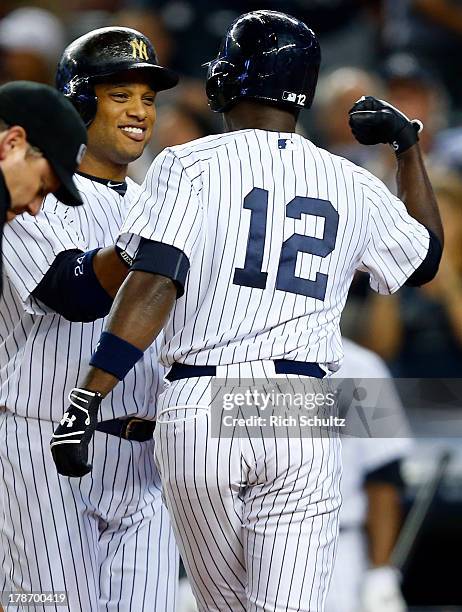 Alfonso Soriano of the New York Yankees flexes for Robinson Cano after hitting a two run home run during the fourth inning against the Baltimore...