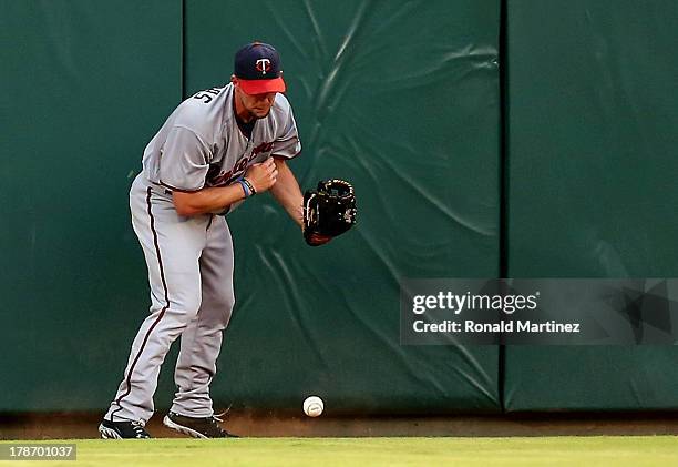 Clete Thomas of the Minnesota Twins runs into the wall after a double by David Murphy of the Texas Rangers at Rangers Ballpark in Arlington on August...