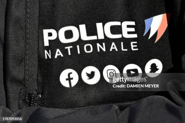 This photograph taken on November 17, 2023 shows the insignia of Frenck police and its social media logos during a ceremony marking the 269th class...