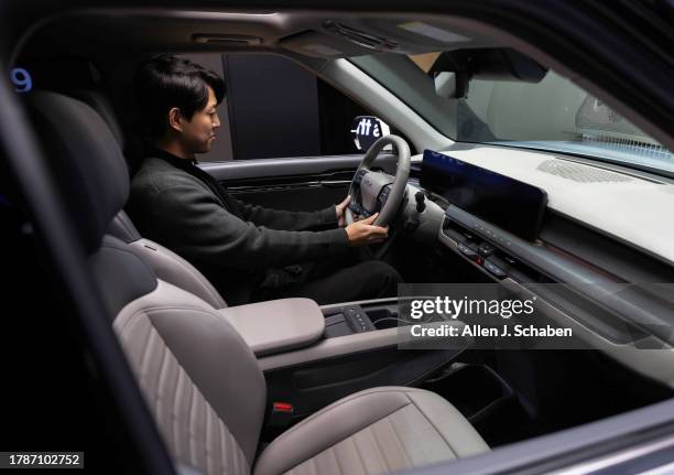 Los Angeles, CA Sung Kwon Go, of Torrance, a Honda car designer, checks out the interior of the Kia EV9 at the LA Auto Show, one of the world's...