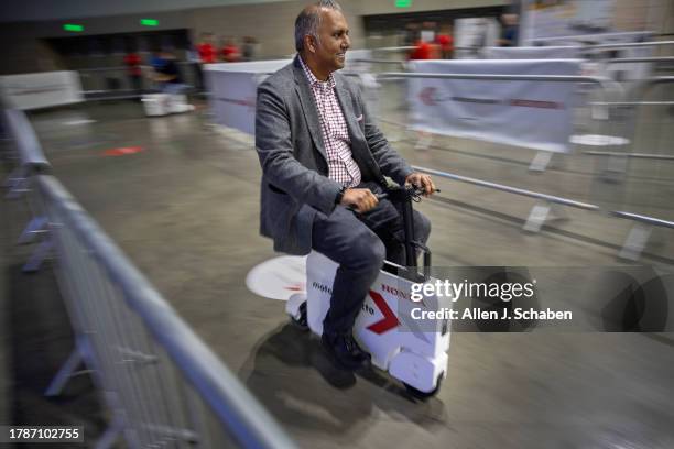 Los Angeles, CA A man takes Honda's folding Motocompo scooter for a test drive at the LA Auto Show, one of the world's largest auto and mobility...