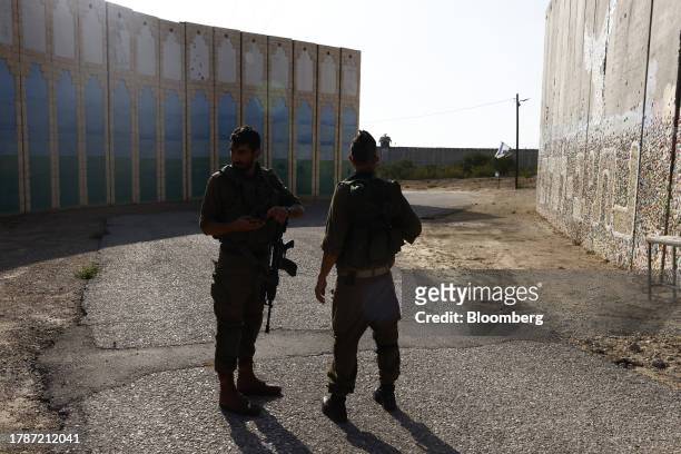 Israeli soldiers on patrol beside a security barrier near the border fence with Gaza Strip, center, in the moshav Netiv HaAsara, southern Israel, on...