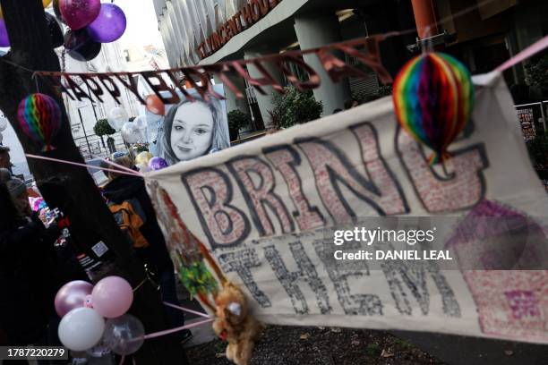 Ballons and banners are picturing during a gathering outside the office of the NGO Save The Children International, in London, on November 17, 2023...