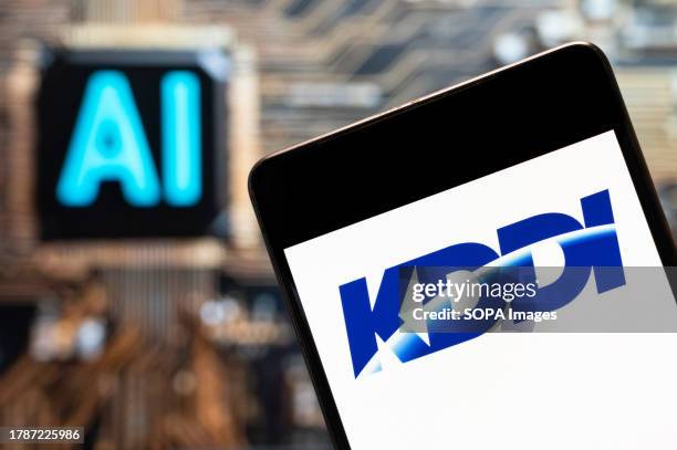 In this photo illustration, the Japanese telecommunications operator company, KDDI logo seen displayed on a smartphone with an Artificial...