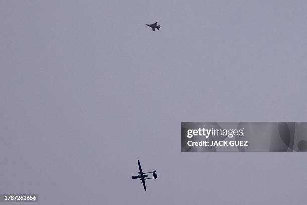 An Israeli unmanned aerial vehicle and a fighter jet fly over the border with the Gaza Strip in southern Israel on November 17, 2023 amid the ongoing...