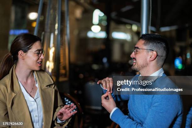 couple communicates passionately through sign language in a romantic cafe garden - how to say your beautiful in sign language stock pictures, royalty-free photos & images