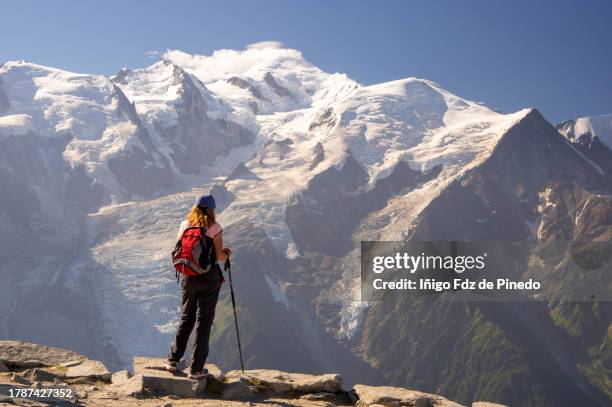 woman hiking along the grand balcon sud with stunning views to  mont blanc massif and the chamonix valley, chamonix-mont-blanc, haute-savoie, france. - blanc stock pictures, royalty-free photos & images