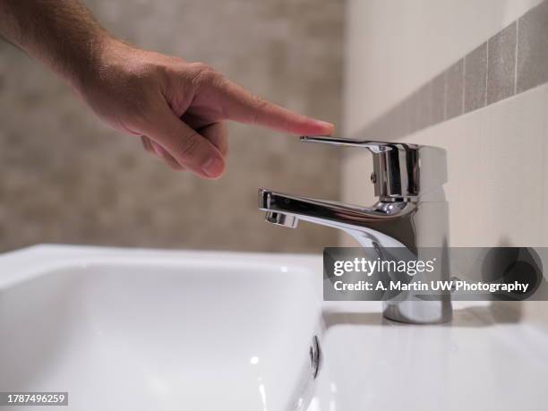 save water. volunteer keeps turning off the running water in the bathroom to protect environment. - water close up stock pictures, royalty-free photos & images