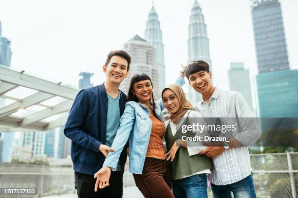 south east asian youth in the city. group of diverse young asian people looking at camera while standing on saloma bridge - cultura da malásia imagens e fotografias de stock
