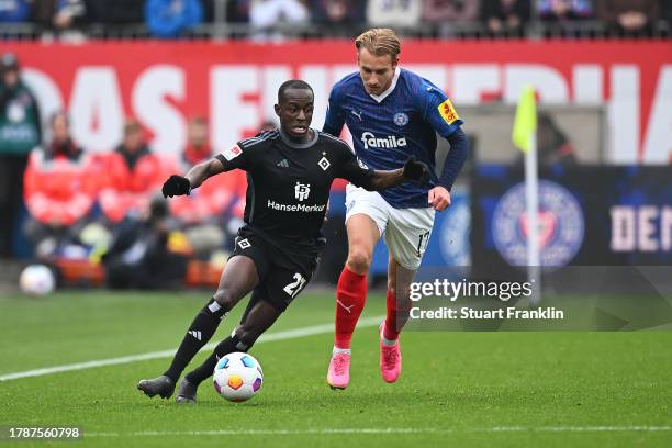 Jean-Luc Dompe of Hamburger SV and Timo Becker of Holstein Kiel battle for the ball during the Second Bundesliga match between Holstein Kiel and...