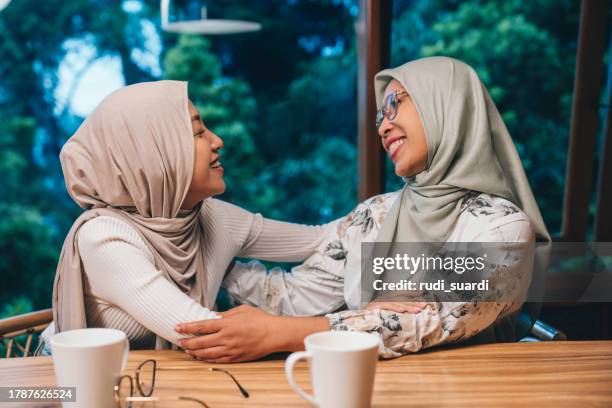 muslimische mutter und tochter umarmen sich - indonesischer archipel stock-fotos und bilder