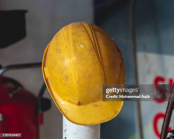 yellow safety helmet in garage - établi photos et images de collection