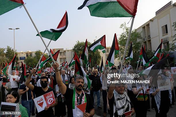 Protesters wave Palestinian flags during a solidarity sit-in with the Gaza Strip, in Manama on November 17 amid ongoing battles between Israel and...