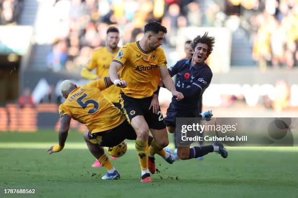 Bryan Gil of Tottenham Hotspur is challenged by Mario Lemina and Max Kilman of Wolverhampton Wanderers during the Premier League match between...