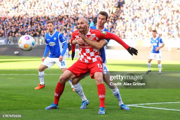 Ludovic Ajorque of 1.FSV Mainz 05 and Christoph Zimmermann of SV Darmstadt 98 battle for the ball during the Bundesliga match between SV Darmstadt 98...