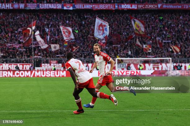 Harry Kane of Bayern Munich celebrates with teammate Dayot Upamecano after scoring the team's second goal during the Bundesliga match between FC...