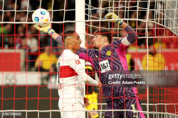 Gregor Kobel of Borussia Dortmund makes a save whilst under pressure from Enzo Millot of VfB Stuttgart following a shot from from Deniz Undav of VfB...