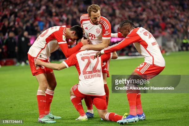 Raphael Guerreiro of Bayern Munich celebrates with teammates after scoring the team's third goal during the Bundesliga match between FC Bayern...