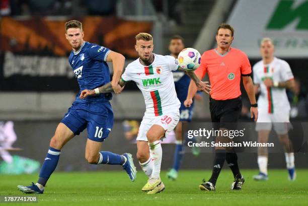 Niklas Dorsch of FC Augsburg and Anton Stach of TSG 1899 Hoffenheim battle for the ball during the Bundesliga match between FC Augsburg and TSG...