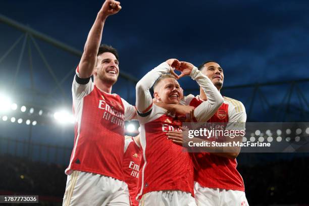 Oleksandr Zinchenko of Arsenal celebrates with teammates Declan Rice and William Saliba after scoring the team's third goal during the Premier League...