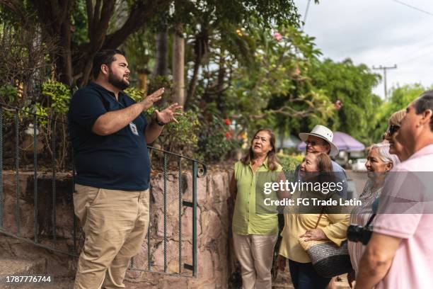 private tourist guide explaining the place history to tourists outdoors - guided stock pictures, royalty-free photos & images