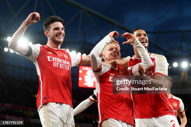 Oleksandr Zinchenko of Arsenal celebrates with teammates Declan Rice and William Saliba after scoring the team's third goal during the Premier League...