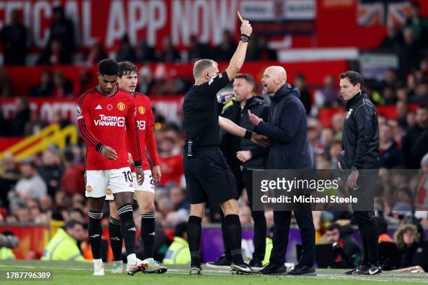 Referee Graham Scott shows a yellow card to Erik ten Hag, Manager of Manchester United, during the Premier League match between Manchester United and...