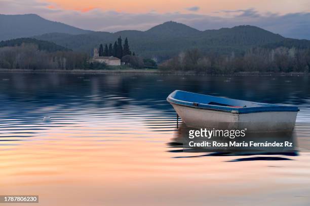 rowboat and reflection in lake of bayonles at sunset.  (estany de banyoles) - banyoles stockfoto's en -beelden