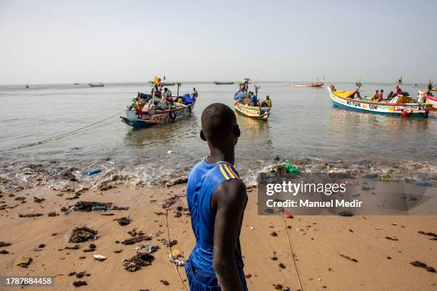 Men unload the fishing boats known as cayucos, also used as migration transport to reach the Canary Islands, which register more than 32,000 people...