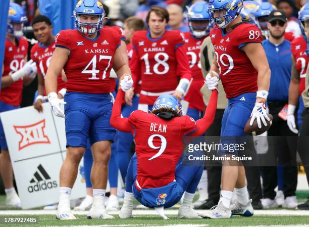Quarterback Jason Bean of the Kansas Jayhawks is helped to his feet by teammates during the 1st half of the game against the Texas Tech Red Raiders...